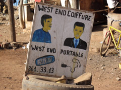 For those who can't read, signs are often made with pictures as well as with words : as you can see here this is a barber shop and a mobile phone shop.