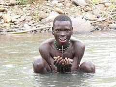 Jeune homme Surma se baignant dans un cours d’eau proche du village.