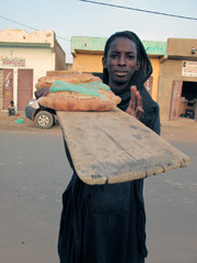 Jeune homme de l’ethnie Soninké proposant du pain fraîchement sorti du four.