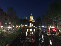 En soirée, l'Oudezijds Voorburgwal, souvent appelé le canal Oz Voorburgwal. La basilique de Saint-Nicolas est visible à l'arrière-plan.