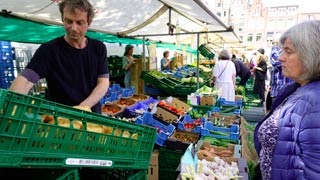 Un marchand de fruits et légumes au marché du matin à Amsterdam.
