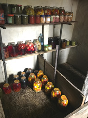 Dans sa cave, Maria à ses conserves préparées avec les légumes de son jardin.